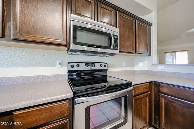 a kitchen with stainless steel appliances a stove microwave and sink