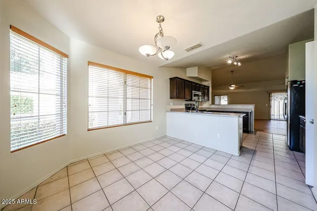 a kitchen with kitchen island granite countertop a stove a sink and a refrigerator