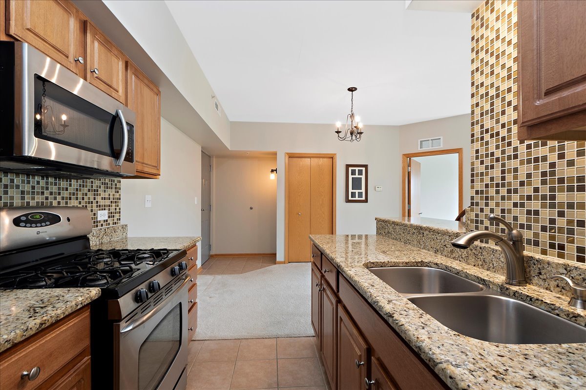19806 Wolf Road, Unit 405 Mokena, IL 60448 - Photo 5 of 14 a kitchen that has a sink and a stove