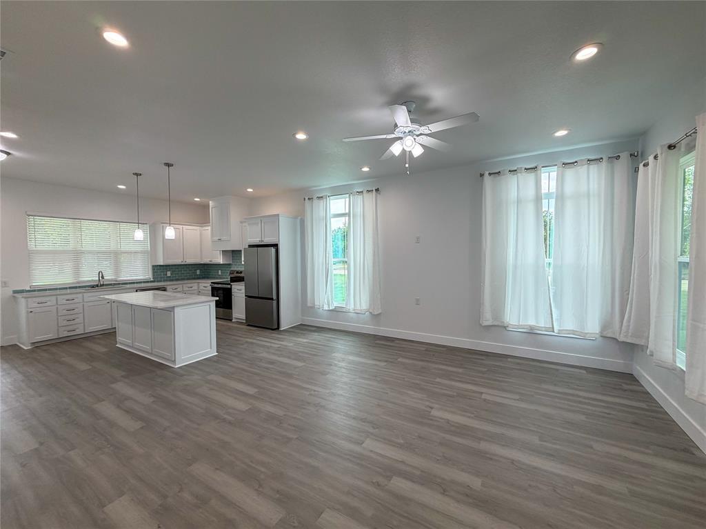 4200 Williams Road Bellmead, TX 76705 - Photo 3 of 22 an open kitchen with kitchen island white cabinets and stainless steel appliances