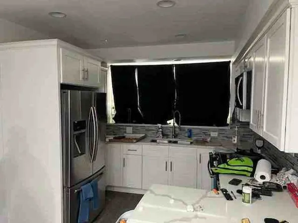 a kitchen with a sink refrigerator and cabinets