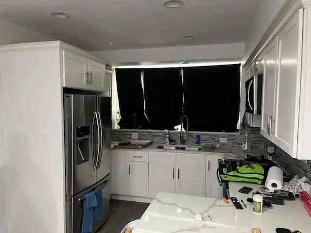 a kitchen with a sink refrigerator and cabinets