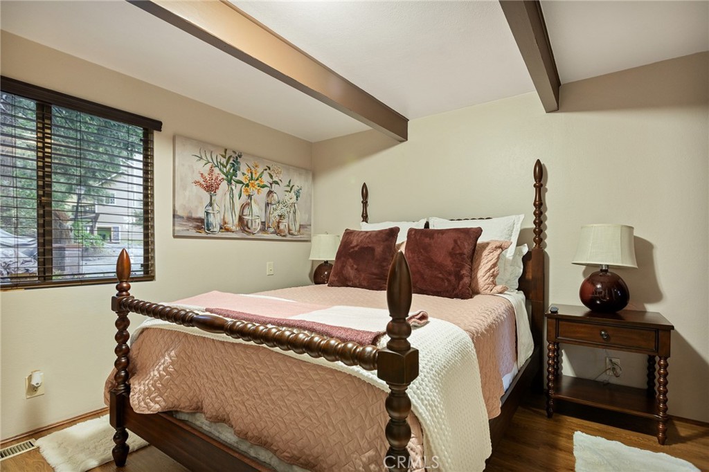 31353 Lightfoot Way Running Springs, CA 92382 - Photo 15 of 42 a bedroom with a bed and wooden floor