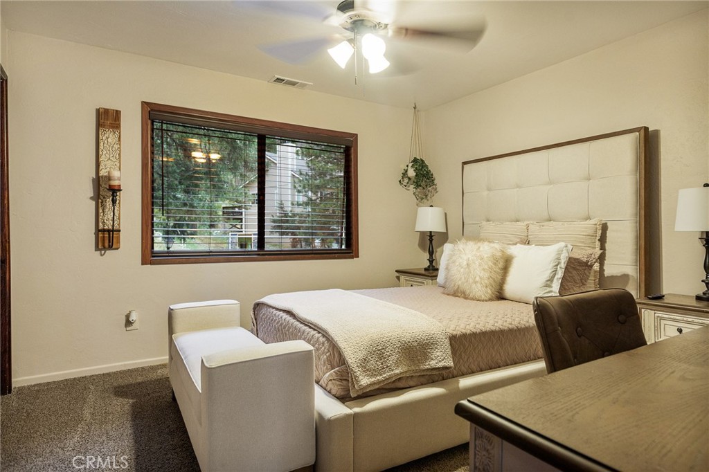 31353 Lightfoot Way Running Springs, CA 92382 - Photo 23 of 42 a bedroom with a large bed and a chandelier