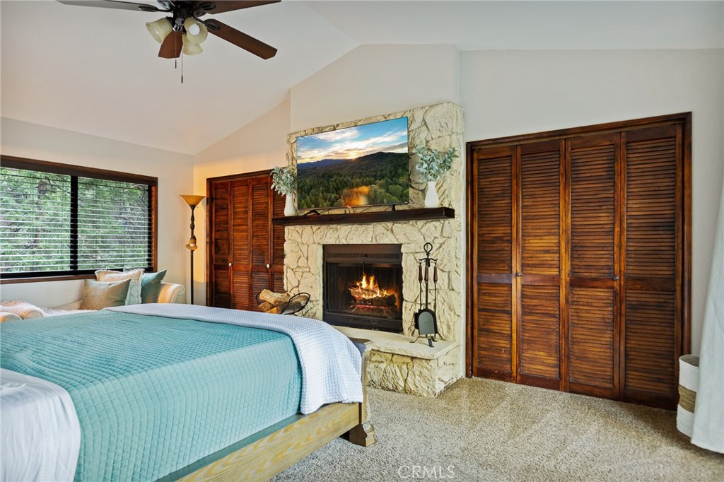31353 Lightfoot Way Running Springs, CA 92382 - Photo 26 of 42 a bedroom with a bed and a fireplace