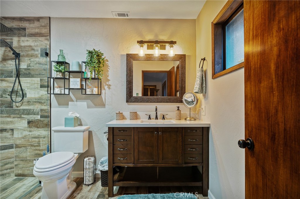 31353 Lightfoot Way Running Springs, CA 92382 - Photo 29 of 42 a bathroom with a toilet a sink and mirror