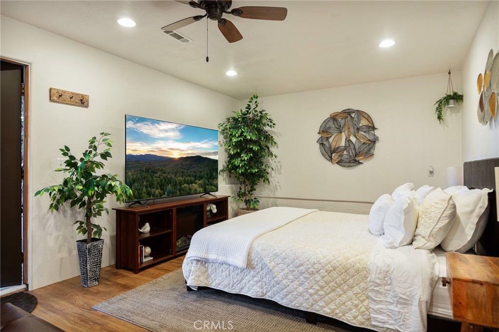 31353 Lightfoot Way Running Springs, CA 92382 - Photo 39 of 42 a bedroom with a large bed and a potted plant