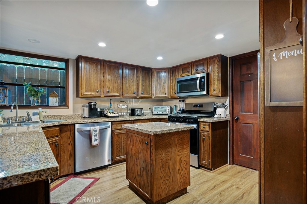 31353 Lightfoot Way Running Springs, CA 92382 - Photo 8 of 42 a kitchen with stainless steel appliances granite countertop a stove a sink dishwasher a refrigerator and a microwave oven with wooden floor
