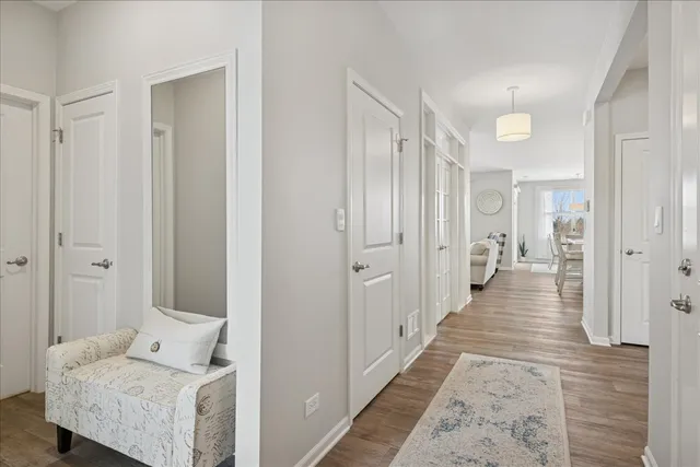 a view of a hallway with wooden floor and furniture