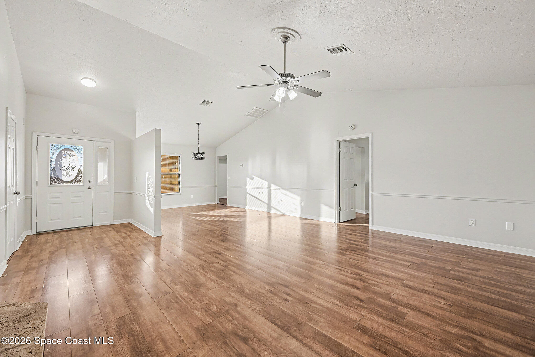 110 Cardinal Drive Sebastian, FL 32958 - Photo 3 of 23 a view of a livingroom with wooden floor a ceiling fan and windows