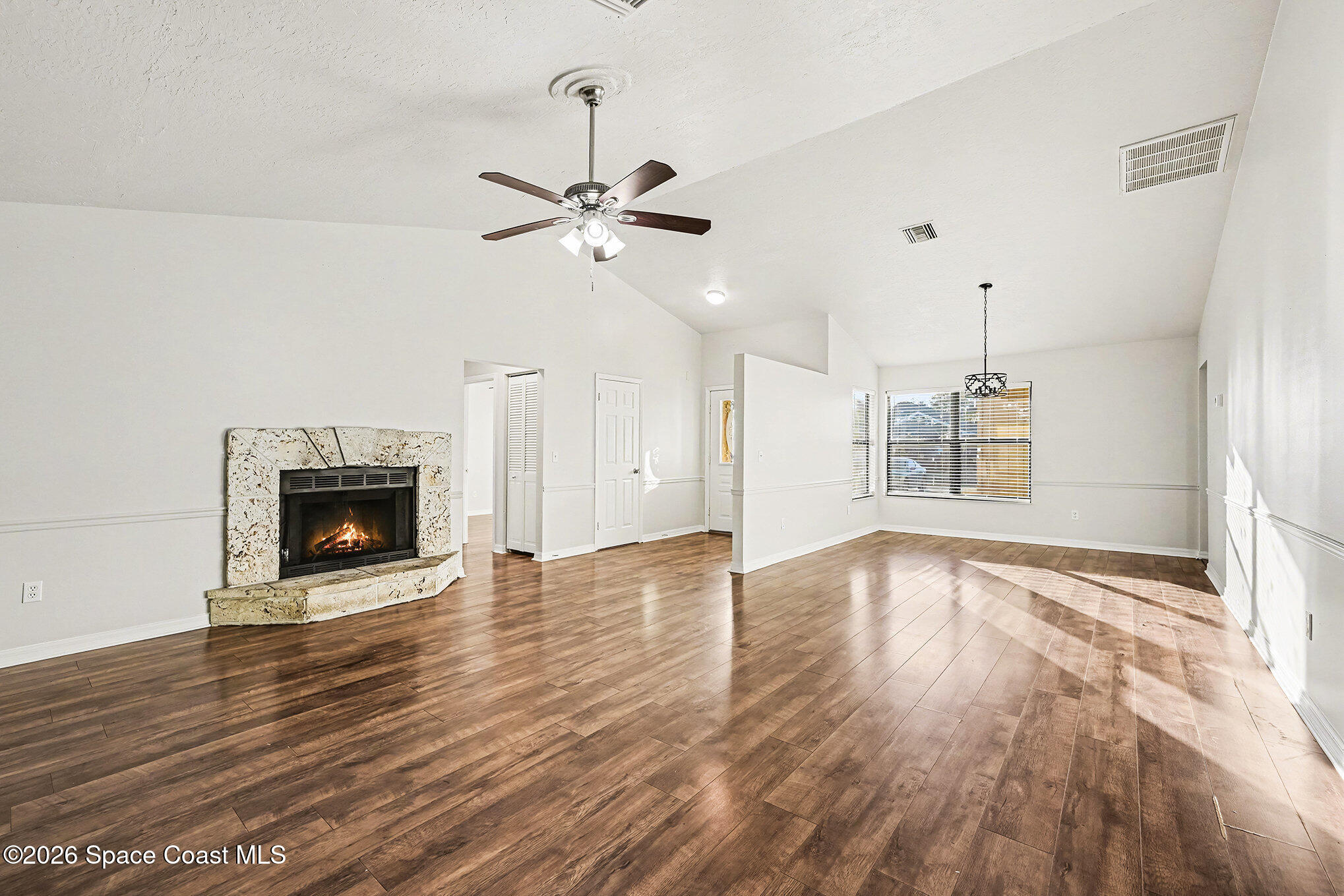 110 Cardinal Drive Sebastian, FL 32958 - Photo 6 of 23 a view of an empty room with a kitchen and wooden floor