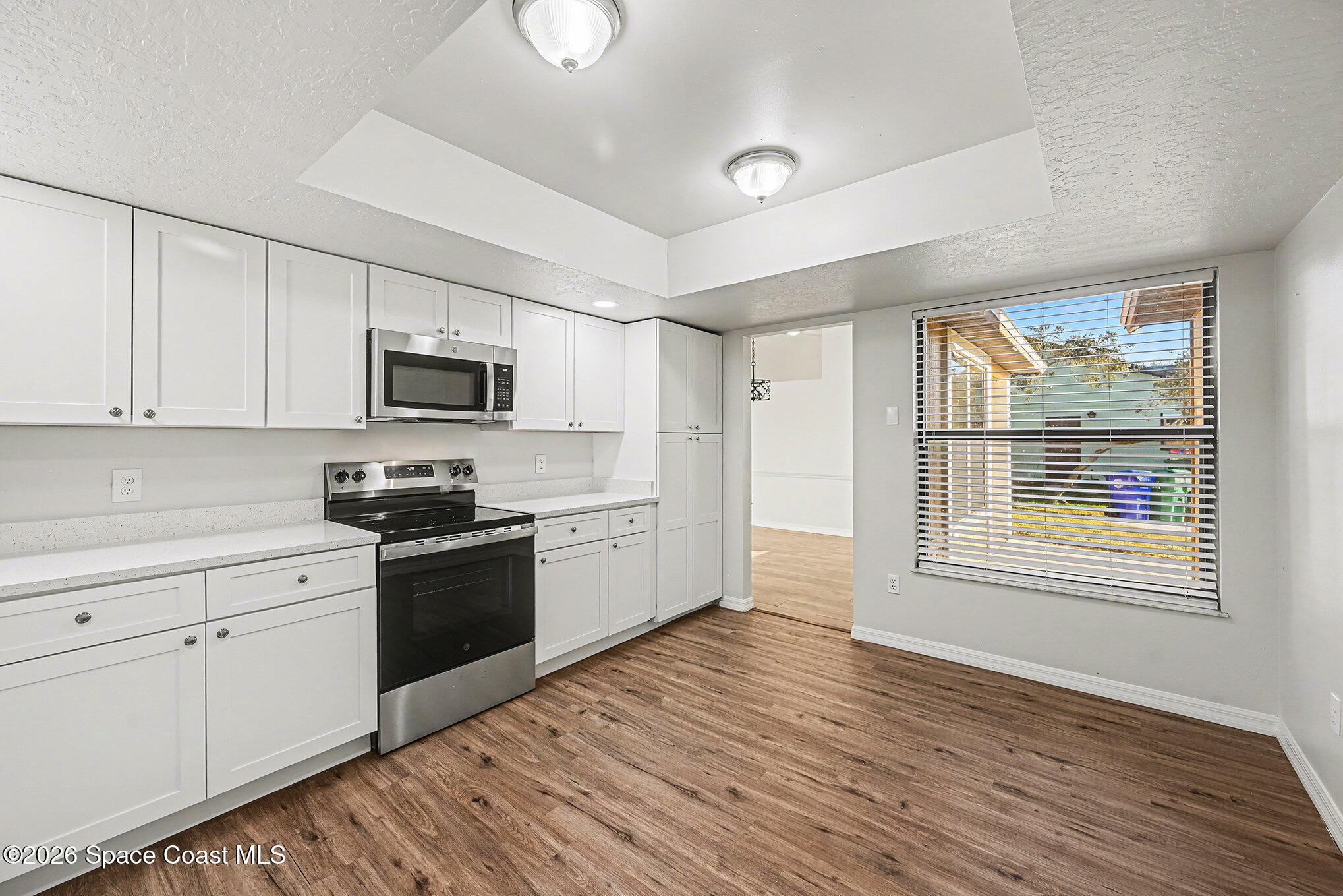110 Cardinal Drive Sebastian, FL 32958 - Photo 9 of 23 a kitchen with granite countertop a stove top oven a sink dishwasher and a refrigerator with wooden floor