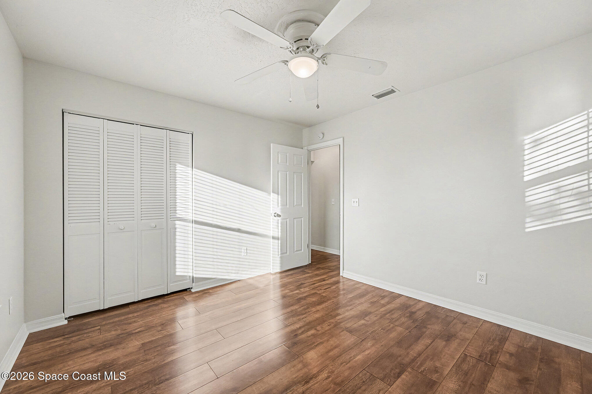 110 Cardinal Drive Sebastian, FL 32958 - Photo 10 of 23 wooden floor in an empty room with a window