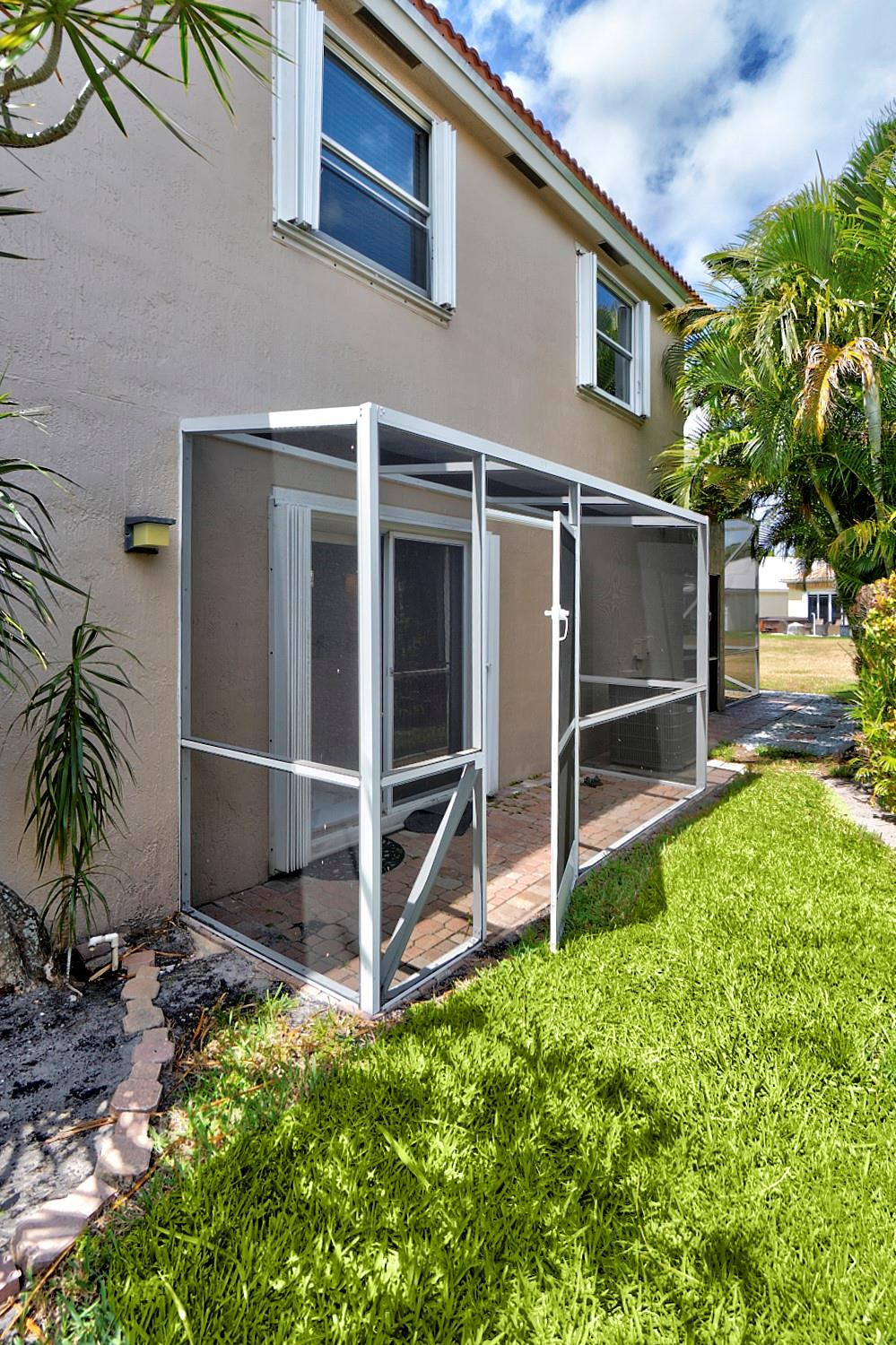 6357 Brava Way Boca Raton, FL 33433 - Photo 23 of 73 a backyard of a house with lawn chairs and potted plants