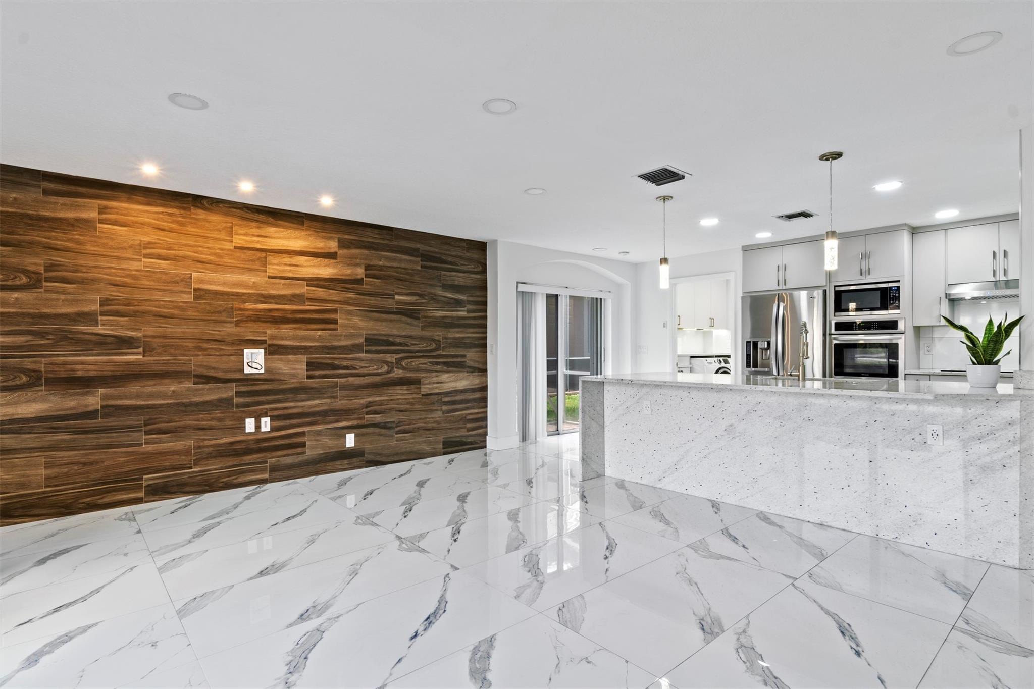 6357 Brava Way Boca Raton, FL 33433 - Photo 42 of 73 a view of kitchen with stainless steel appliances wooden floor and living room