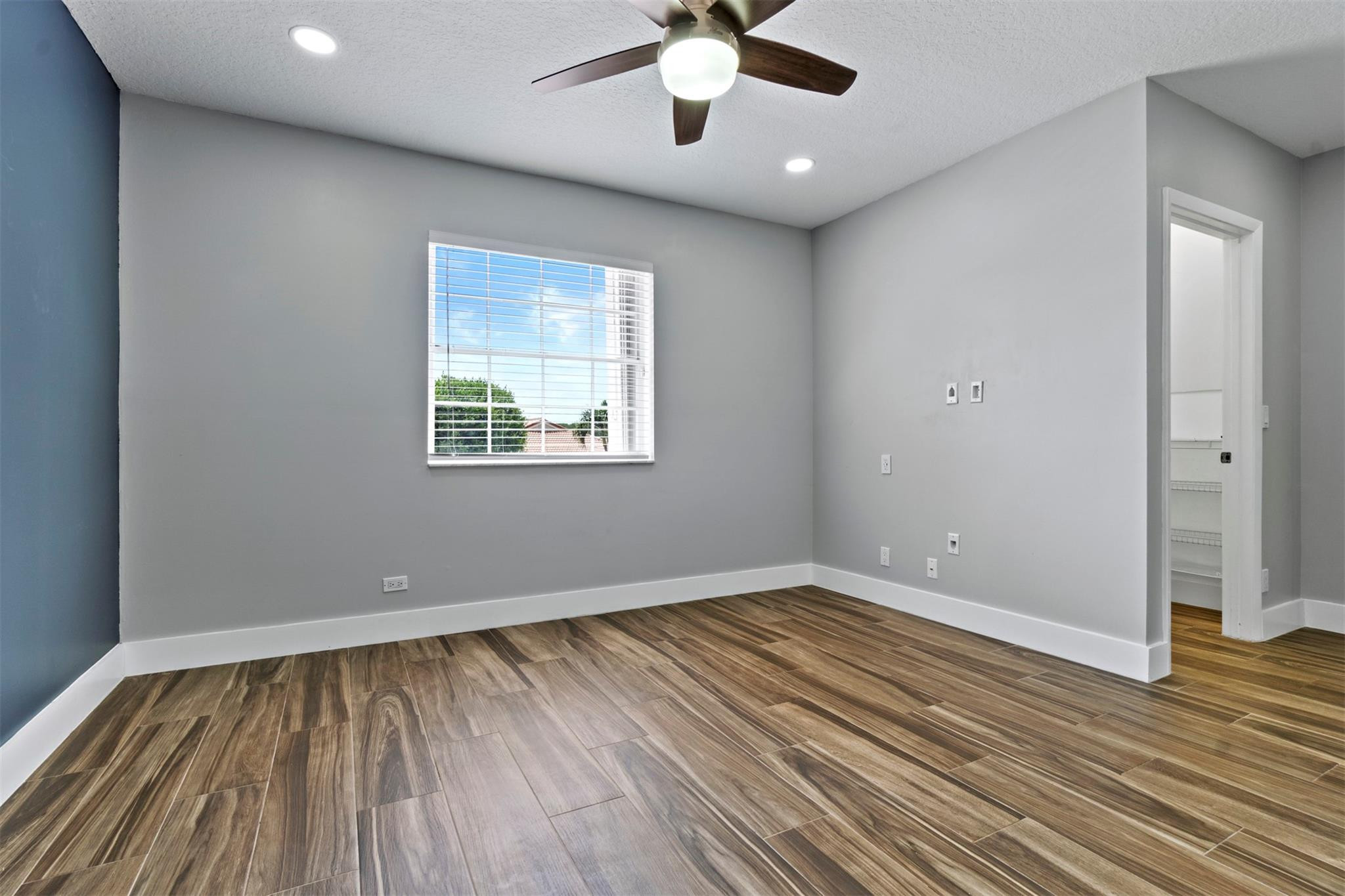 6357 Brava Way Boca Raton, FL 33433 - Photo 63 of 73 an empty room with wooden floor chandelier fan and windows