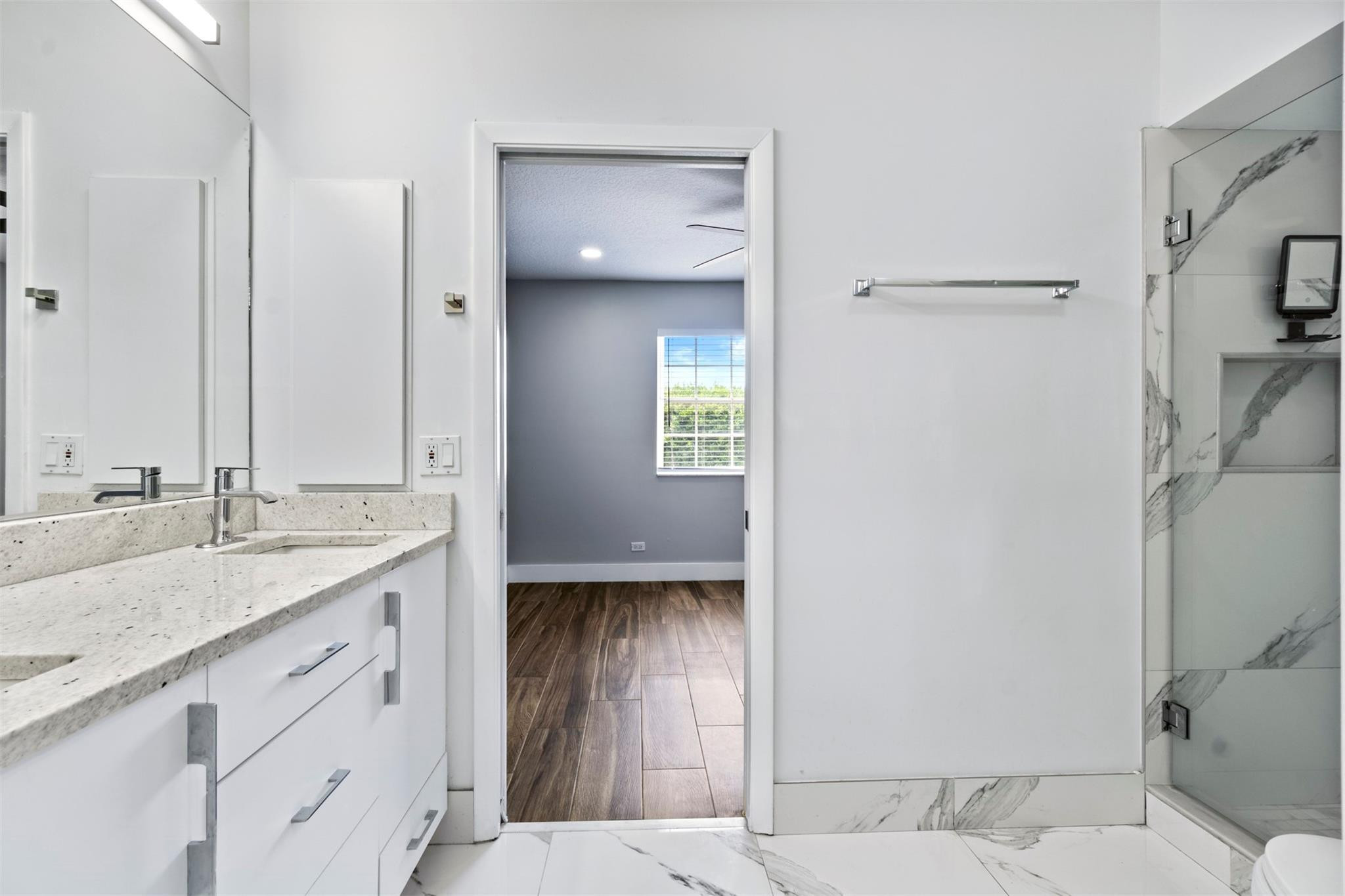 6357 Brava Way Boca Raton, FL 33433 - Photo 66 of 73 a en suite bathroom with a granite countertop sink and a mirror