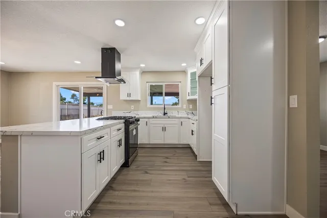 a large kitchen with a stove top oven sink and cabinets