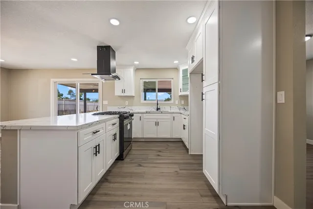 a large kitchen with a stove top oven sink and cabinets
