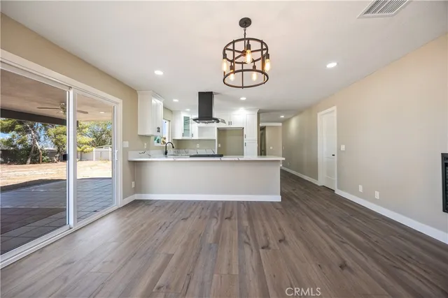 a large kitchen with a wooden floor and stainless steel appliances