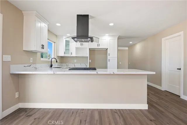 a large kitchen with stainless steel appliances a large counter top a sink and a stove