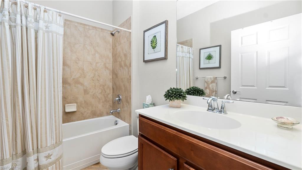 5113 Da Vinci Way Ave Maria, FL 34142 - Photo 15 of 31 a bathroom with a sink a toilet and a large mirror