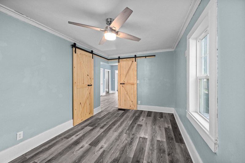 1419 17th Street Moline, IL 61265 - Photo 11 of 28 a view of a room with wooden floor a ceiling fan and windows