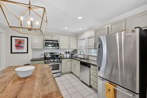 a kitchen with stainless steel appliances granite countertop a refrigerator sink and stove