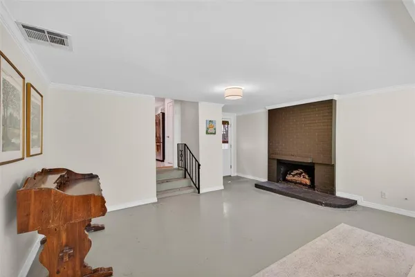 a view of an empty room with a fireplace and a window