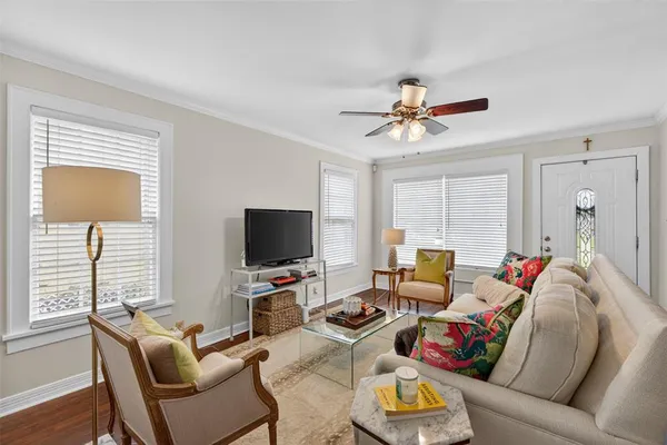 a living room with furniture a flat screen tv and a window