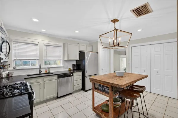 a kitchen with a sink a stove and chairs