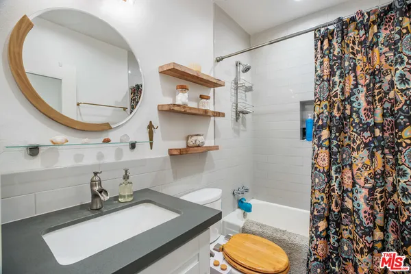 a bathroom with a sink vanity mirror and toilet