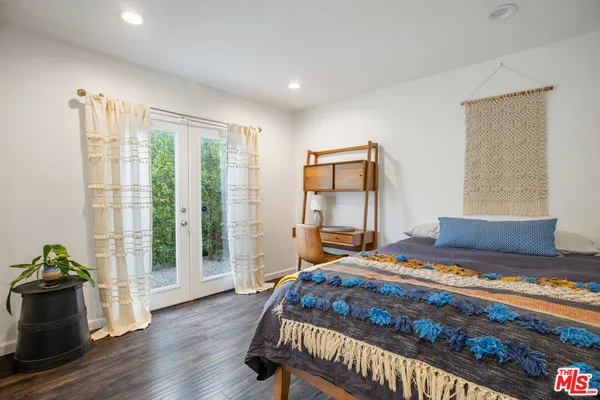 a bedroom with a large bed and a potted plant