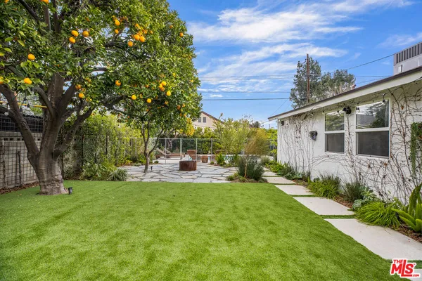a view of a house with backyard sitting area and garden