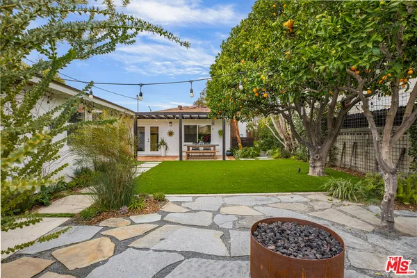 a front view of a house with a garden and trees