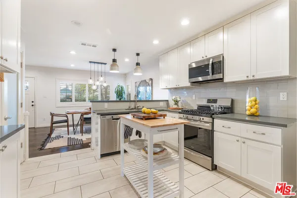 a kitchen with white cabinets and appliances