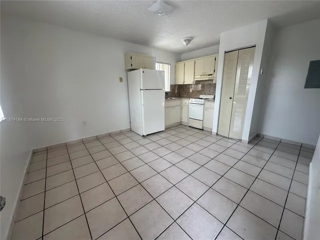 a kitchen with a sink refrigerator and cabinets