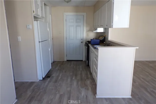 a view of a storage and utility room with wooden floor