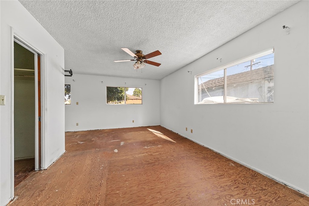 4224 Falcon Avenue Long Beach, CA 90807 - Photo 12 of 16 an empty room with windows and a ceiling fan