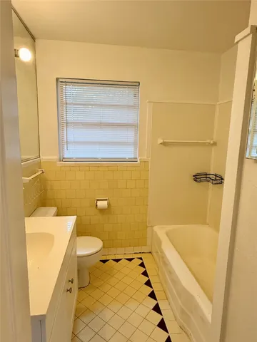 a bathroom with a sink mirror toilet and next to a window