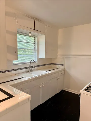 a view with a sink and dishwasher with wooden floor