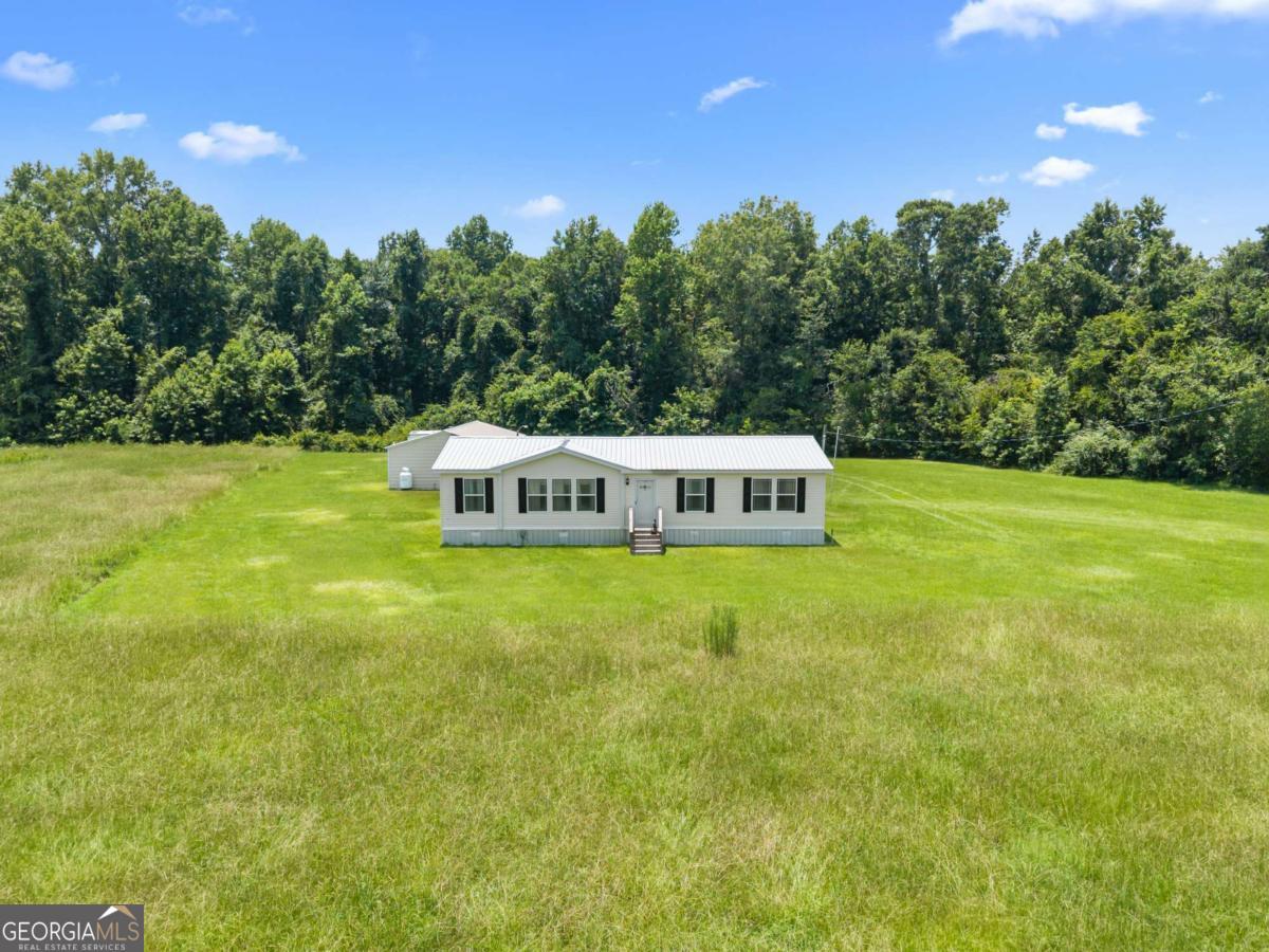 3516 Bennetts Landing Road Millen, GA 30442 - Photo 31 of 34 a white house with a big yard and large trees
