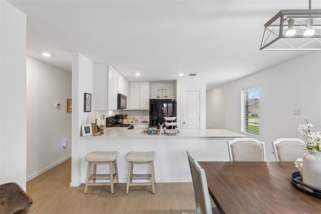 14163 Kempt Drive Pilot Point, TX 76258 - Photo 6 of 29 Enjoy effortless flow between the kitchen and dining area, while the adjacent hallway leads to two secondary bedrooms and a full bath—perfectly positioned to provide separation and privacy from the primary suite.