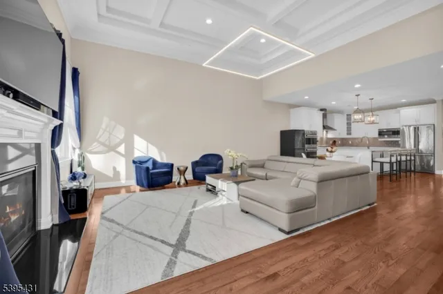 a view of a dining room and livingroom with furniture wooden floor a chandelier
