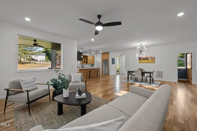 a living room with furniture and a wooden floor