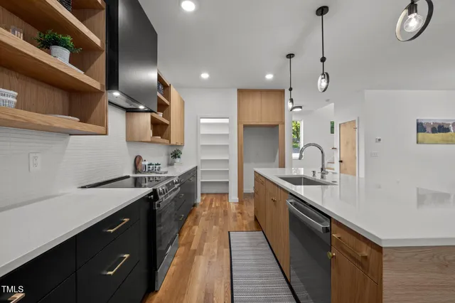 a large kitchen with stainless steel appliances granite countertop a sink a stove and a refrigerator