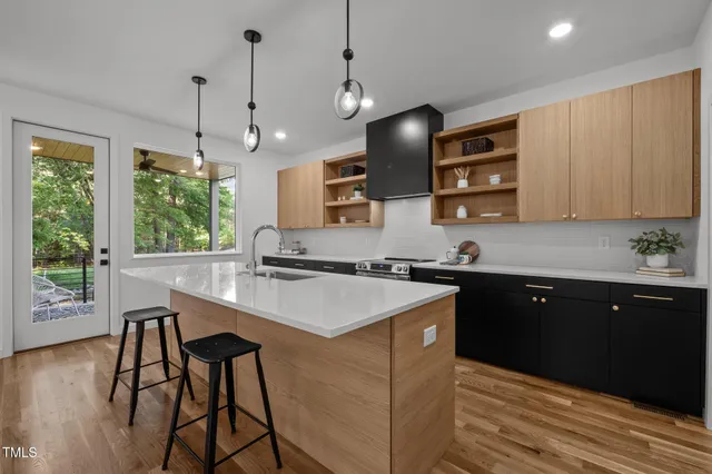 a kitchen with a stove a sink a counter space and wooden floor