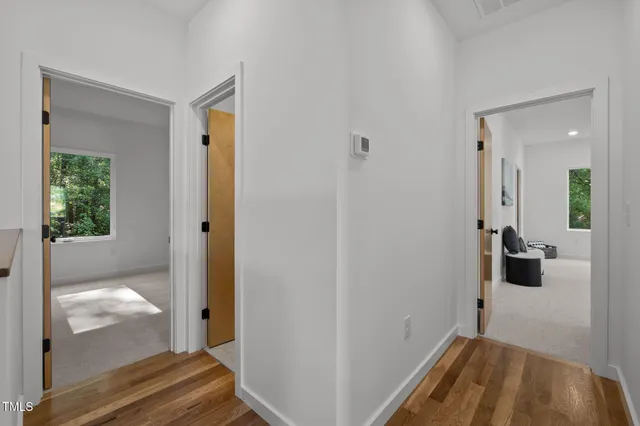 a view of a hallway with a livingroom and a bathroom with sink