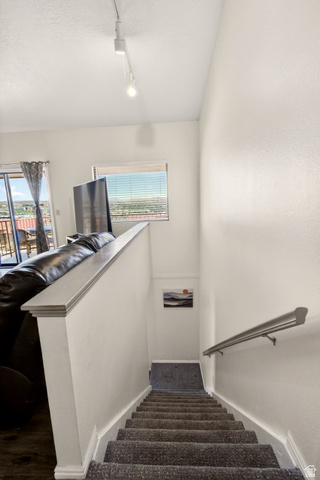 161 West 950 South, Unit Q1 St. George, UT 84770 - Photo 22 of 37 Stairway with plenty of natural light, rail lighting, and a textured ceiling