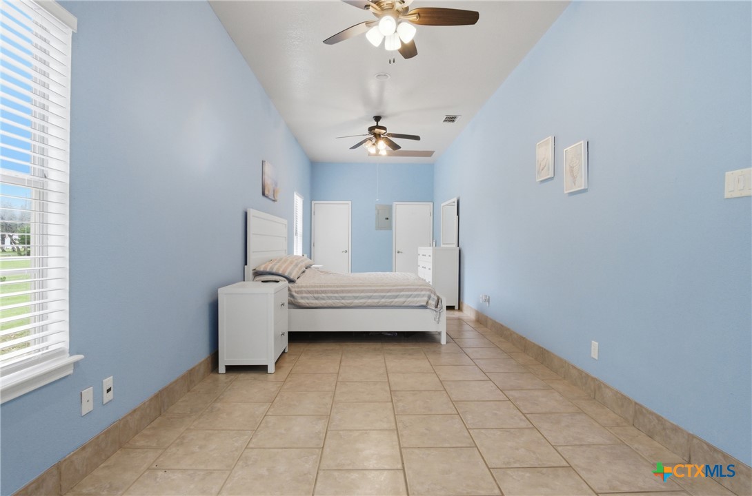 642 Phantom Rider Trail Spring Branch, TX 78070 - Photo 31 of 41 a spacious bedroom with a bed and a chandelier
